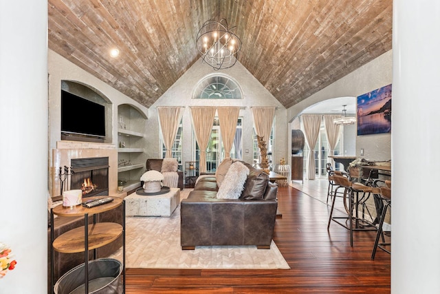 living room featuring wooden ceiling, built in features, vaulted ceiling, and an inviting chandelier