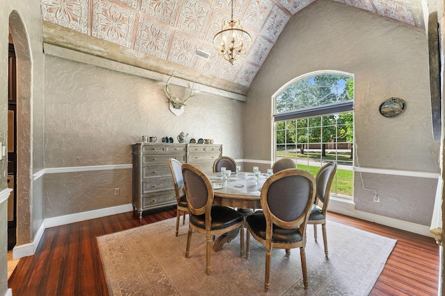 dining room with a chandelier, a textured wall, baseboards, and wood finished floors