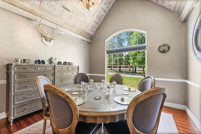 dining room with dark wood-style floors, a textured wall, high vaulted ceiling, and baseboards