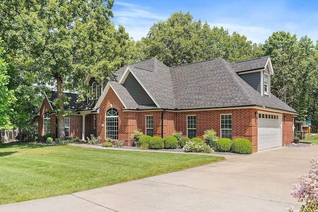 view of front of property featuring a shingled roof, brick siding, driveway, and a front lawn