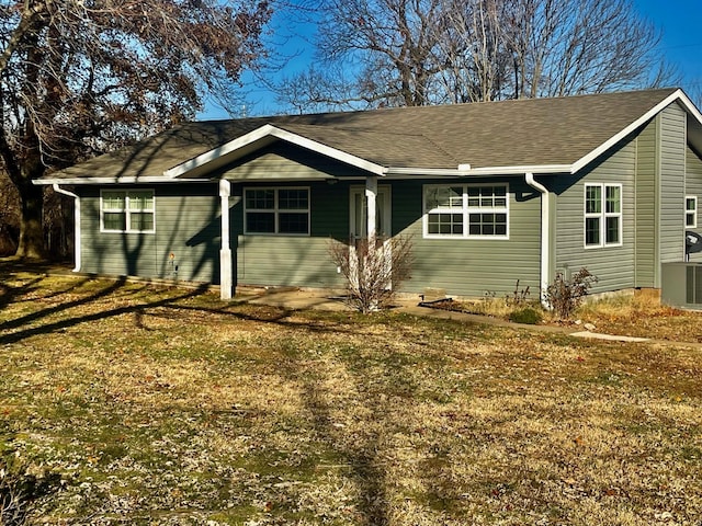 single story home featuring a front lawn, central AC, and roof with shingles