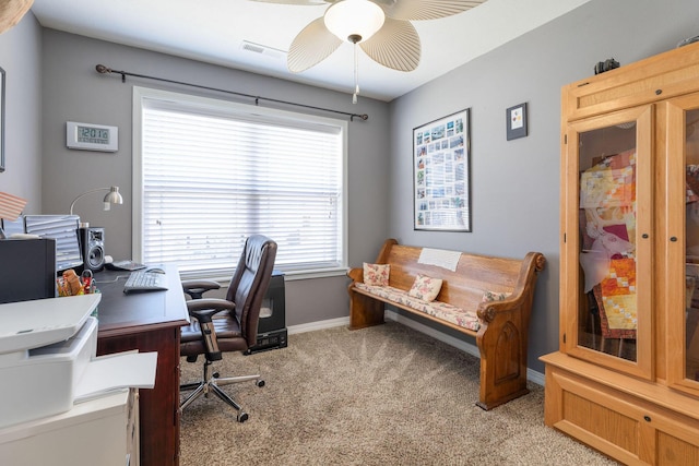 office space featuring light carpet, ceiling fan, visible vents, and baseboards