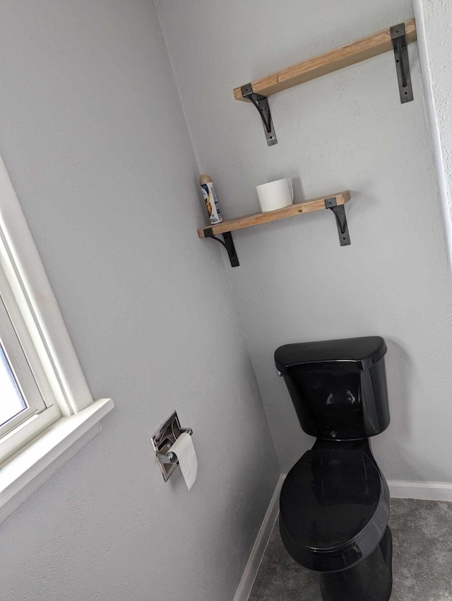 bathroom featuring toilet and baseboards