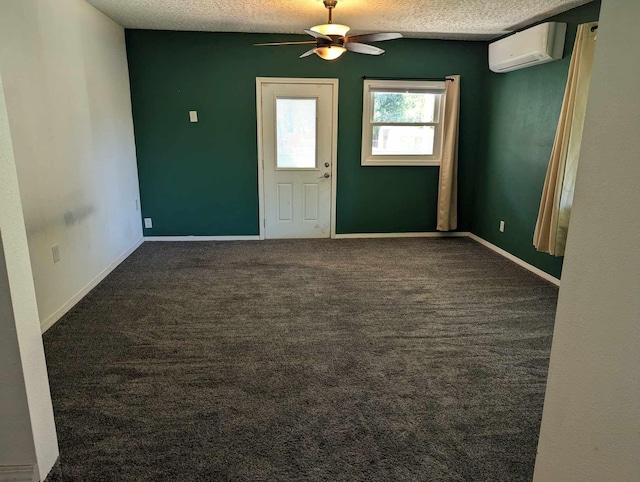 unfurnished room with carpet, a textured ceiling, a wall unit AC, and baseboards