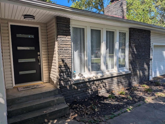 entrance to property with brick siding and a chimney