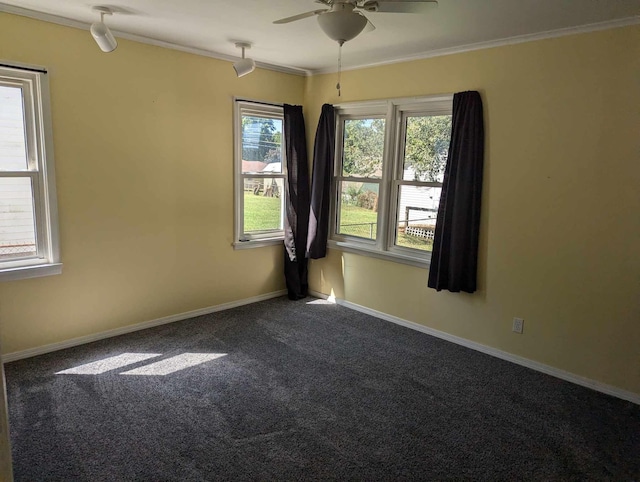 spare room featuring a ceiling fan, dark colored carpet, crown molding, and baseboards