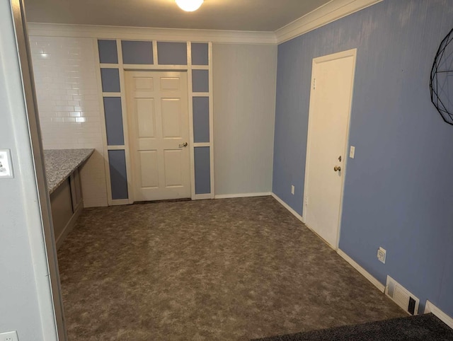 empty room featuring carpet, visible vents, and crown molding