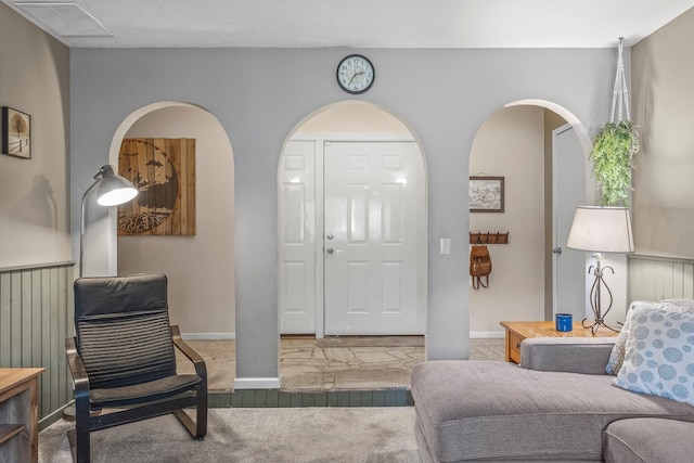 foyer with visible vents and carpet flooring