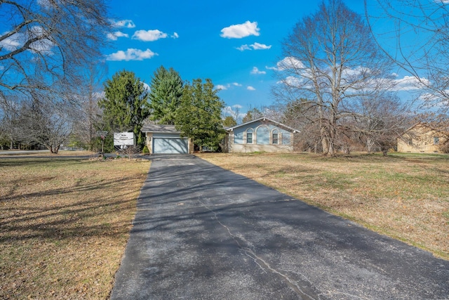 view of front of property with a front yard and a detached garage