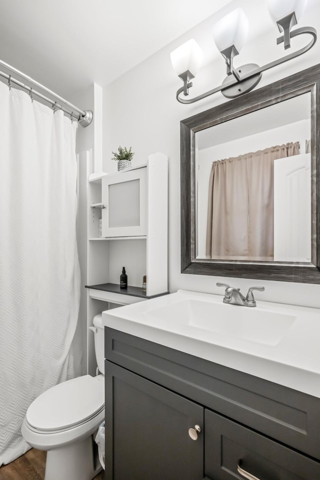 bathroom with curtained shower, vanity, toilet, and wood finished floors