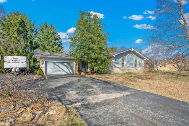 ranch-style house featuring a garage and driveway