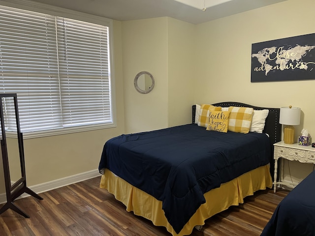 bedroom featuring baseboards and dark wood-type flooring