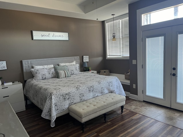 bedroom with french doors, dark wood finished floors, and baseboards