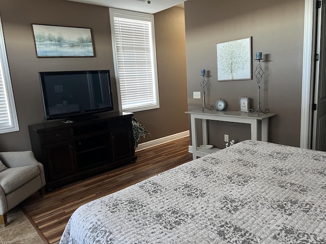 bedroom featuring wood finished floors and baseboards