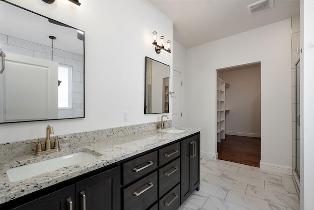 full bathroom featuring marble finish floor, a sink, visible vents, and baseboards