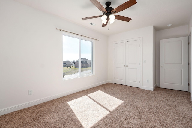 unfurnished bedroom featuring baseboards, visible vents, ceiling fan, carpet floors, and a closet