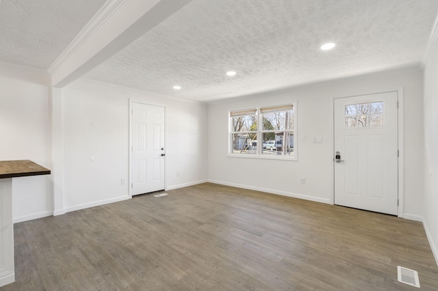 foyer featuring crown molding, a textured ceiling, and wood finished floors