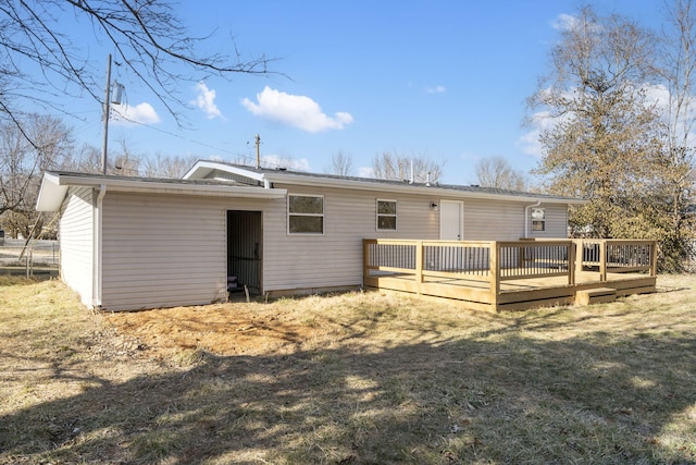 back of property featuring a lawn and a wooden deck