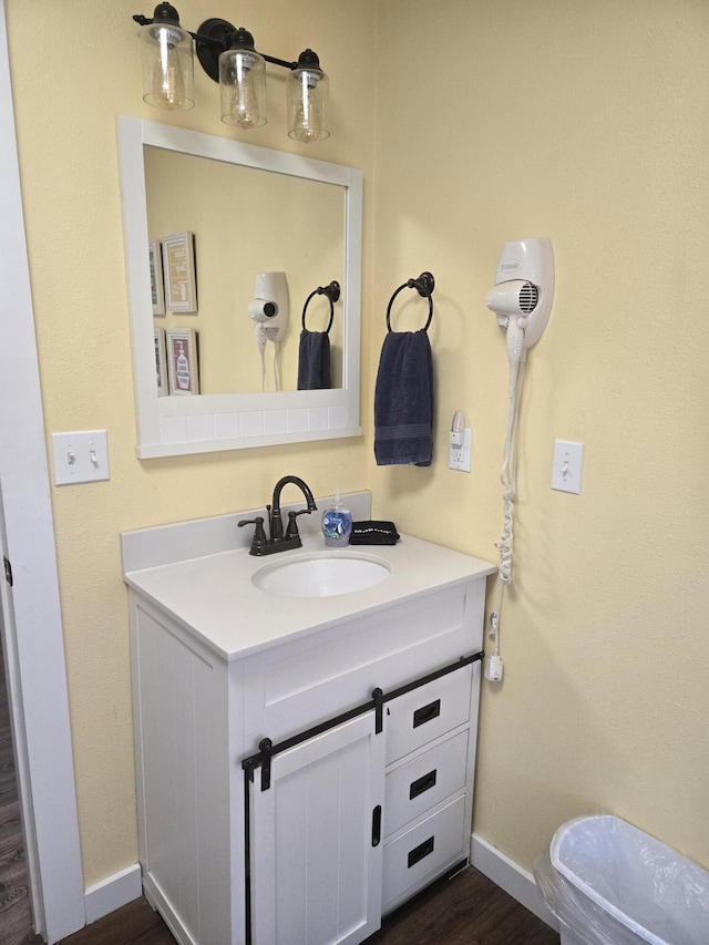 bathroom featuring baseboards, wood finished floors, and vanity