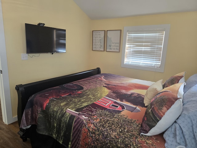 bedroom with vaulted ceiling and wood finished floors