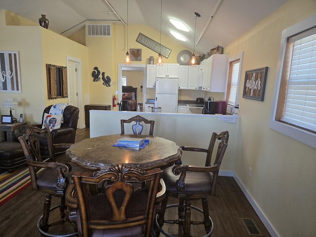 dining room with baseboards, visible vents, vaulted ceiling, and dark wood-type flooring