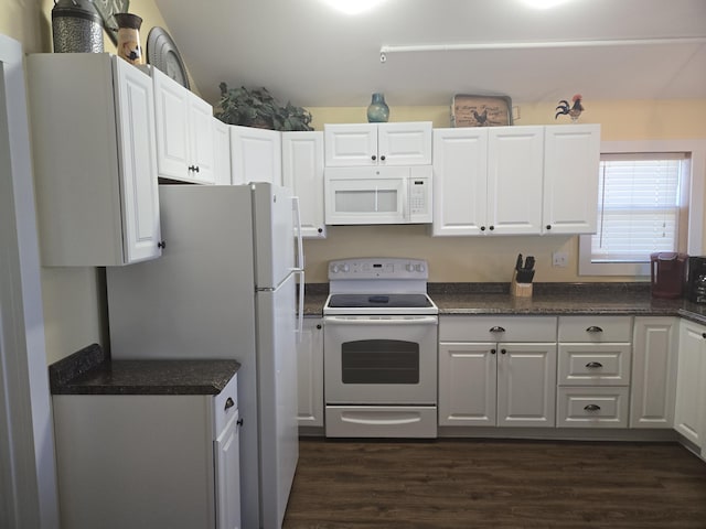 kitchen with dark countertops, white appliances, and white cabinetry