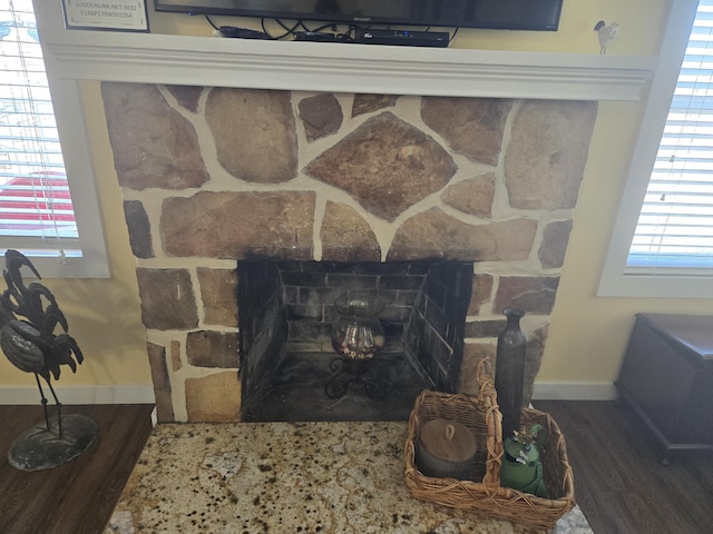 interior details with a fireplace, baseboards, and wood finished floors