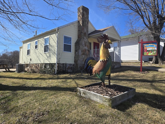 view of home's exterior with a lawn, a chimney, and central AC unit