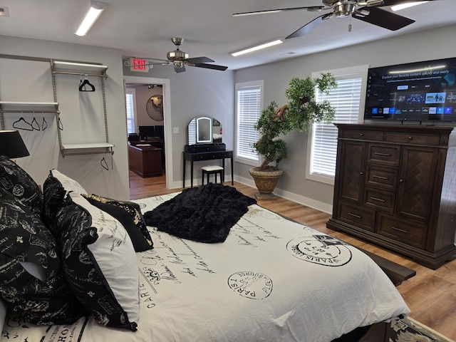 bedroom with ceiling fan, light wood-type flooring, and baseboards