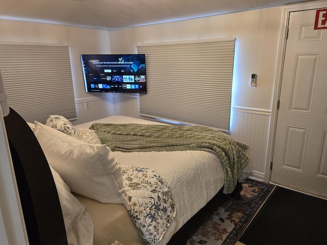 bedroom featuring a wainscoted wall