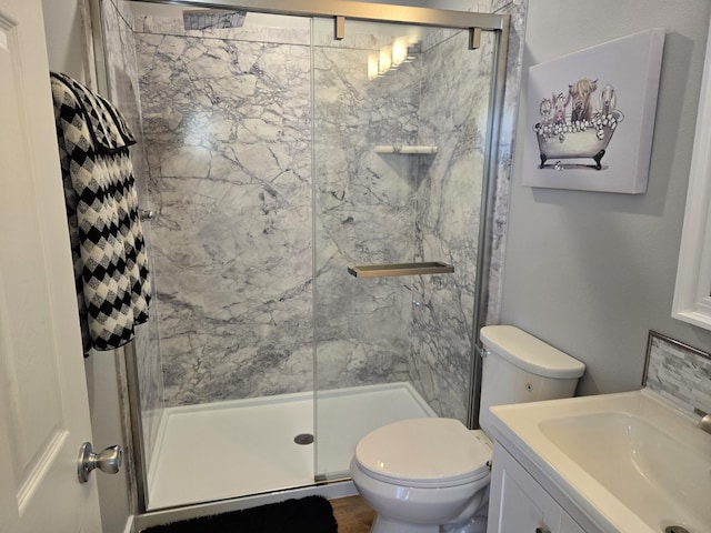 bathroom with vanity, a marble finish shower, and toilet