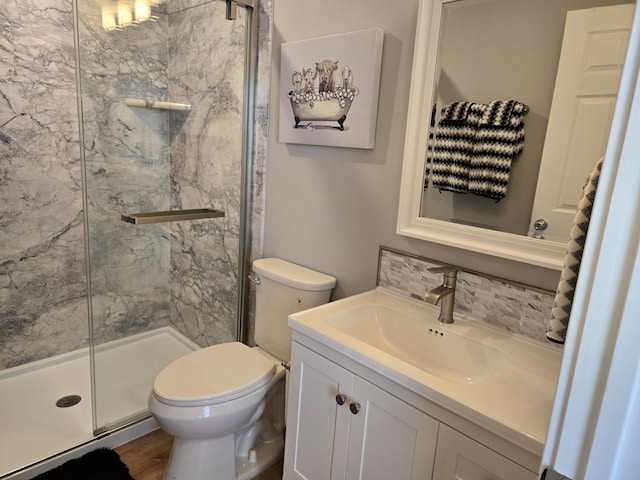 full bath featuring a marble finish shower, decorative backsplash, toilet, wood finished floors, and vanity