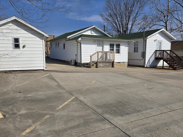 rear view of house featuring driveway and crawl space