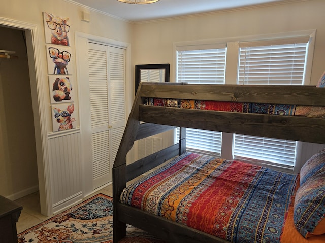 tiled bedroom featuring a closet and crown molding