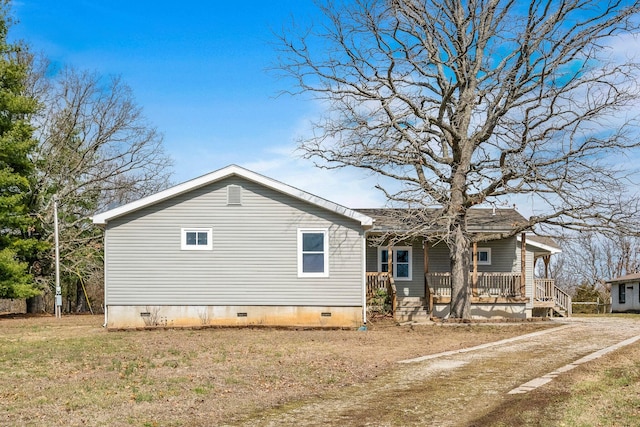 exterior space featuring covered porch, crawl space, and a lawn