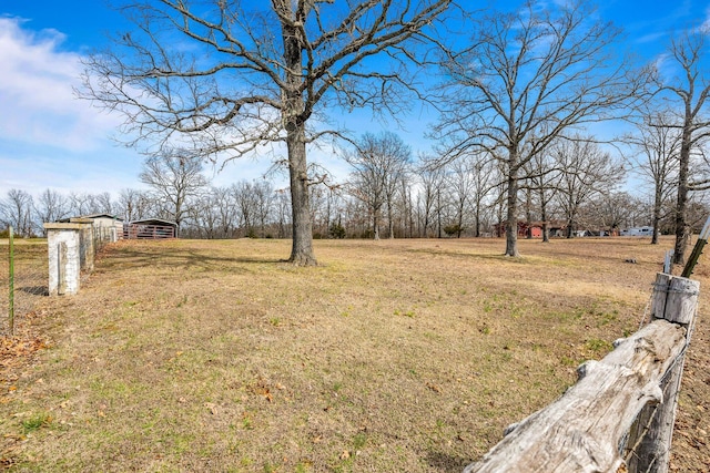 view of yard featuring a rural view and an outdoor structure