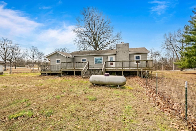 back of house featuring a chimney, fence, and a deck