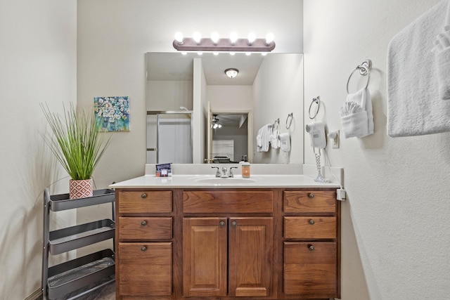 full bath with a ceiling fan, a stall shower, and vanity