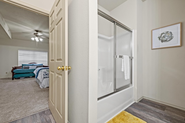 bathroom featuring a ceiling fan, combined bath / shower with glass door, connected bathroom, and wood finished floors