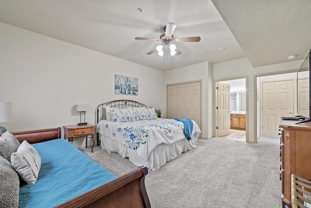 bedroom with light carpet, ceiling fan, a closet, and ensuite bathroom