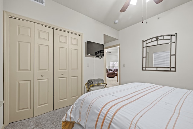 carpeted bedroom with a closet and ceiling fan