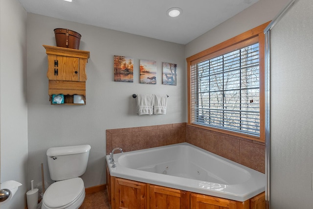 bathroom featuring a jetted tub and toilet