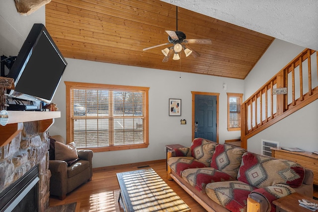 living room with lofted ceiling, wooden ceiling, wood finished floors, stairs, and a fireplace