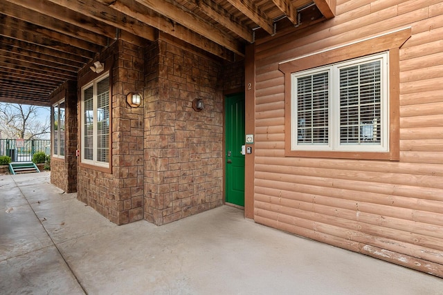 view of exterior entry featuring faux log siding