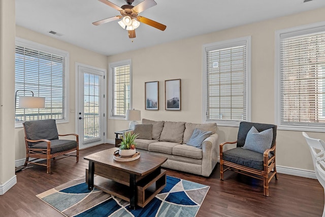 living room featuring baseboards, visible vents, ceiling fan, and wood finished floors