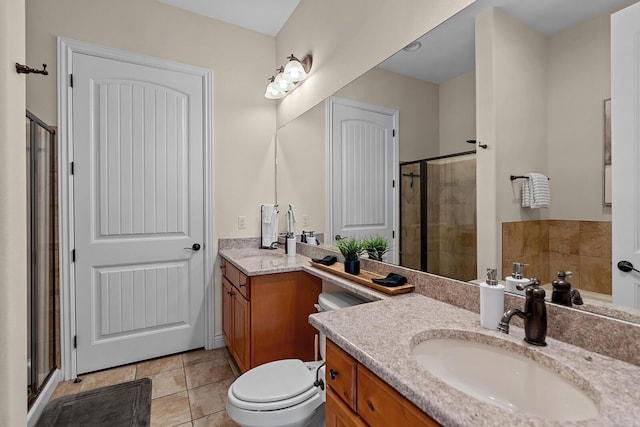 bathroom with toilet, tile patterned flooring, a shower stall, and vanity