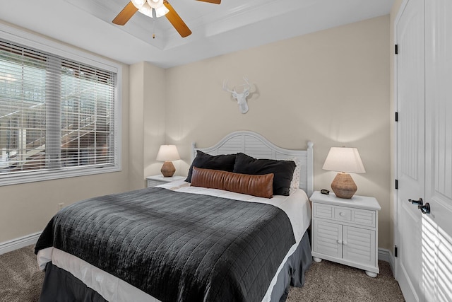 bedroom featuring a ceiling fan, a raised ceiling, carpet flooring, and baseboards