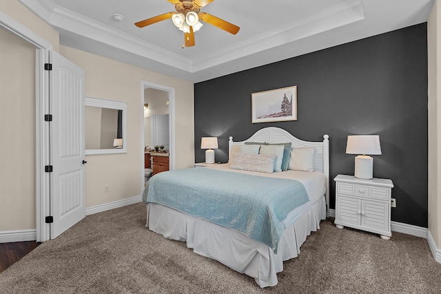 bedroom with an accent wall, ornamental molding, a raised ceiling, and baseboards