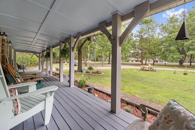 wooden terrace featuring a porch and a yard