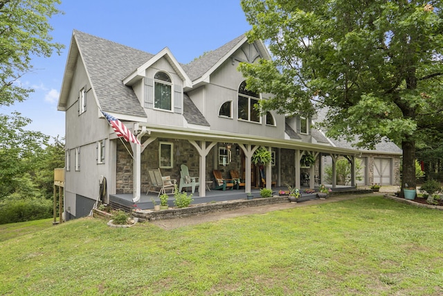 view of front of property featuring stone siding, a front lawn, and roof with shingles